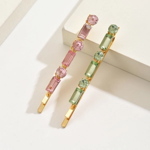 Barrettes élégantes dorées serties de strass roses et verts sur blocs de marbre blanc
