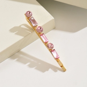 Détail de la barrette dorée avec cristaux roses ronds et rectangulaires alternés