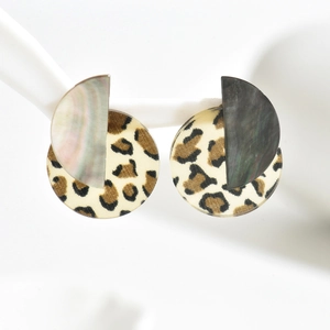 Close-up of C-shaped earrings with leopard print fabric and two-tone shell texture details