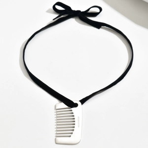 Détail du pendentif peigne avec cordon en daim noir et élégante décoration en nœud