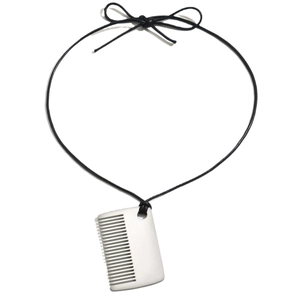 Collier pendentif peigne argenté avec cordon noir et détail nœud sur fond blanc épuré