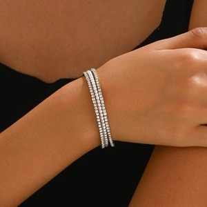 Elegante bracciale da sposa a tre strati con cristalli e perle sul polso di una modella