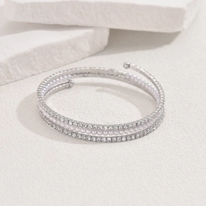 Dettaglio del bracciale a spirale multistrato con perle bianche e strass scintillanti