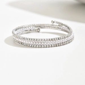Dettaglio di un bracciale a spirale multistrato con cristalli e perle su metallo argento
