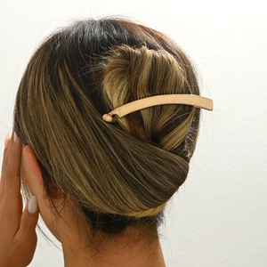 Minimalist matte gold metal hair clip for French ponytail styles with sleek curved design