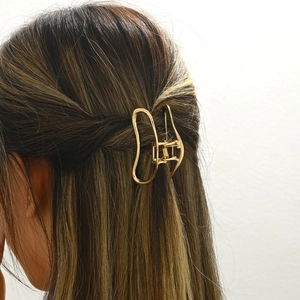 Elegant gold hollow metal cloud hair claw clip styled in a half-up hairstyle
