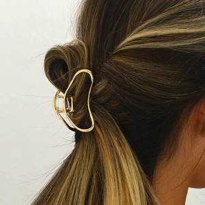 Elegant gold hollow cloud metal hair claw clip shown on a brunette bun hairstyle