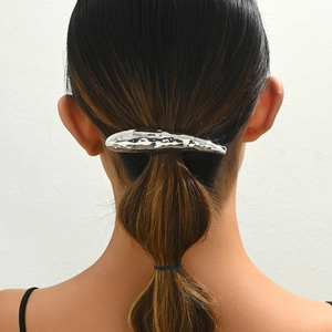 Lava liquid metal hair clip with irregular silver droplet design worn on a ponytail