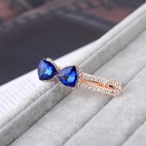 Macro d'une pince à cheveux nœud en or rose avec cristaux bleus et strass brillants