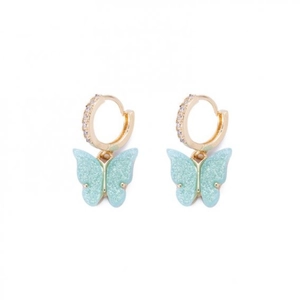 Détail de boucles d'oreilles papillon en résine bleue pailletée avec anneaux dorés