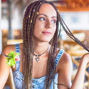100pcs gold and silver dreadlock beads set shown on model in sunny cafe setting
