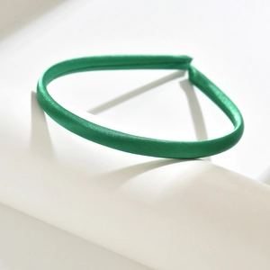 Detail of the smooth satin texture and vibrant green fabric wrap on a slim headband