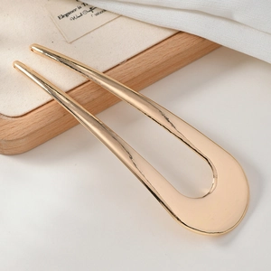 Polished gold U-shaped metal hair pin hair fork for elegant bun hairstyles closeup