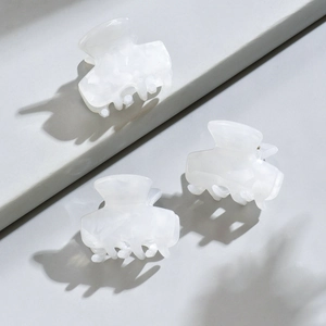Close-up of small pearl white marble acetate hair claws for French vintage styling