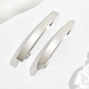 Close-up of polished silver metal spring hair clips with sleek rectangular and oval shapes