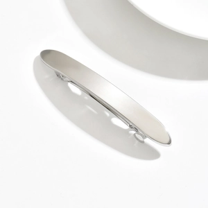 Macro view of long slim silver metal hair clip with a minimalist matte brushed finish