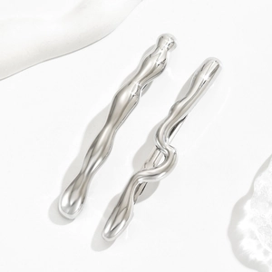 Détail de barrettes en métal liquide argenté avec design ondulé poli et clip arrière métallique