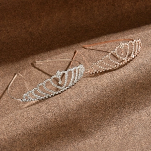 Détail de tiares en forme de cœur argent et or rose avec strass brillants et pendentifs