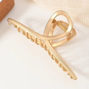 Pince à cheveux élégante en métal doré mat avec un design croisé minimaliste chic