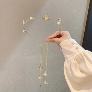 Detailed shot of golden butterfly headband with pearls and long tassel chain fringe