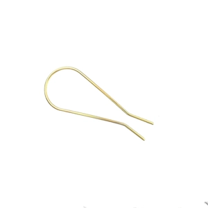 Dettaglio di una forcina per capelli dorata a forma di U con design a goccia minimalista