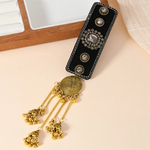 Ethnic style hair clip with golden bells and tassels in a minimalist wood setting
