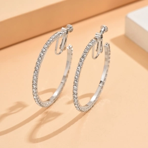 Detailweergave van zilveren schroefclip oorringen bezet met glinsterende strass-stenen