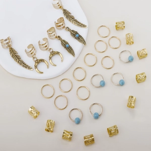 Detailed view of bohemian gold dreadlock rings with moon and feather charms on a display