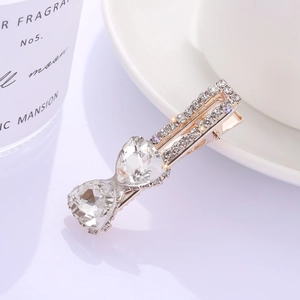 Barrette à cheveux dorée avec deux grands cristaux en forme de cœur et strass brillants
