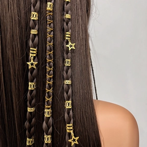 Detail of gold hollow rings and star charms on dark brown braided hair extensions