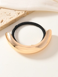Détail d'un anneau de cheveux en métal doré minimaliste avec élastique noir