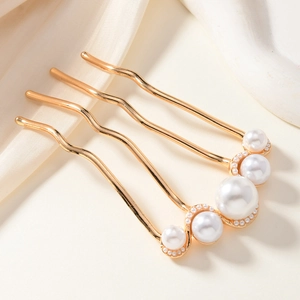 Detail of golden alloy hair comb with four wavy teeth and five elegant faux pearls