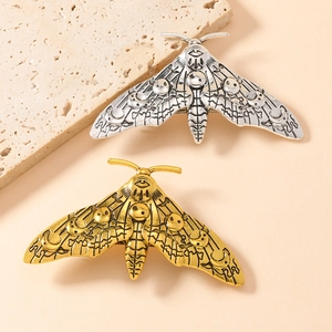 Vintage moth spring hair clips in gold and silver with gothic skull and eye patterns