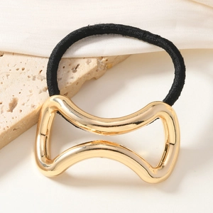 Élastique à cheveux chic avec nœud doré et corde noire sur fond en pierre minimaliste