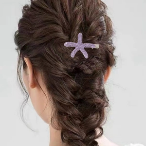 Pince à cheveux étoile de mer violette avec cristaux sur une coiffure tressée femme