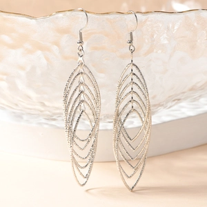 Elegant tiered silver leaf drop earrings with fine texture on textured glass bowl