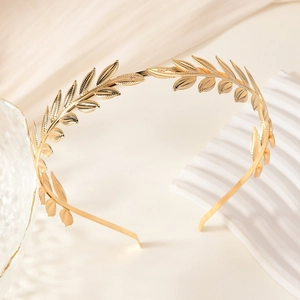 Golden laurel leaf headband with metallic Greek style on warm minimalist background