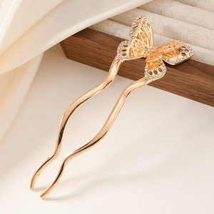 Detail of golden butterfly hair pin featuring intricate metalwork and sparkling rhinestones