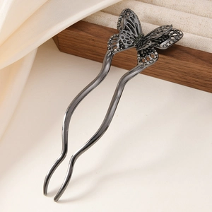 Elegant U-shaped butterfly hair pin with dark grey rhinestones on a vintage wood background