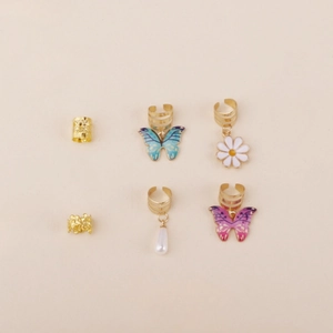 Detail view of gold butterfly and daisy hair rings with pearls in a 6-piece bohemian set