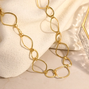Minimalist 18K gold plated interlocking oval chain necklace on a linen background