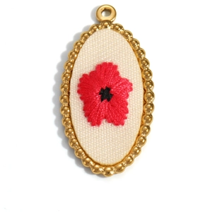 Macro detail of oval 18K gold plated pendant with red flower embroidery on canvas