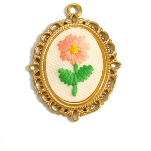 Oval 18K gold plated stainless steel pendant with embroidered daisy floral pattern