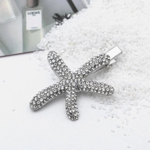 Dettaglio macro di un fermaglio a stella marina argento con strass scintillanti