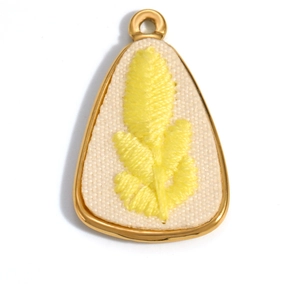 Detailed close-up of oval 18K gold plated pendant featuring yellow embroidered leaves