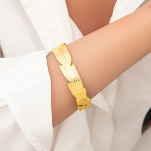 Polished 18k gold plated stainless steel feather cuff bracelet with detailed engraving
