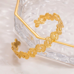 Macro detail of 18k gold plated stainless steel open bangle with butterfly texture