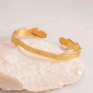 Detailed macro view of gold 18k stainless steel cuff with leaf texture on crystals