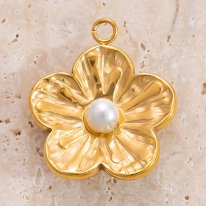 Pendentif fleur dorée à cinq pétales avec perle centrale sur fond de corail blanc