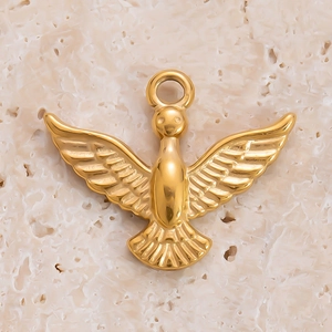 Macro d'un pendentif oiseau doré aux ailes détaillées sur fond de pierre texturée